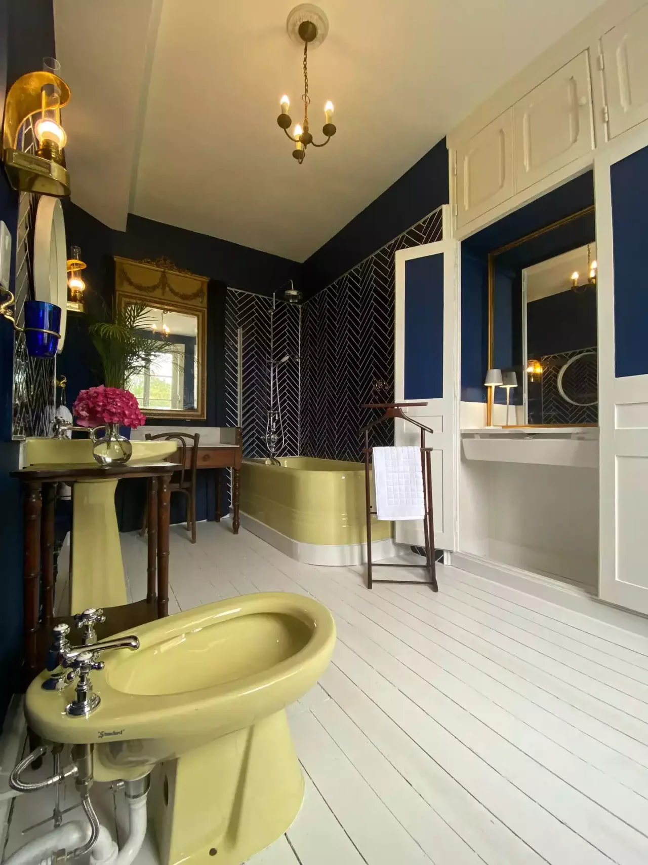 Salle de bain Marina équipée d'un baignoire avec colonne de douche, une coiffeuse, trois miroirs, un bidet et des toilettes - Suite Marina Château Le Bas Bleu