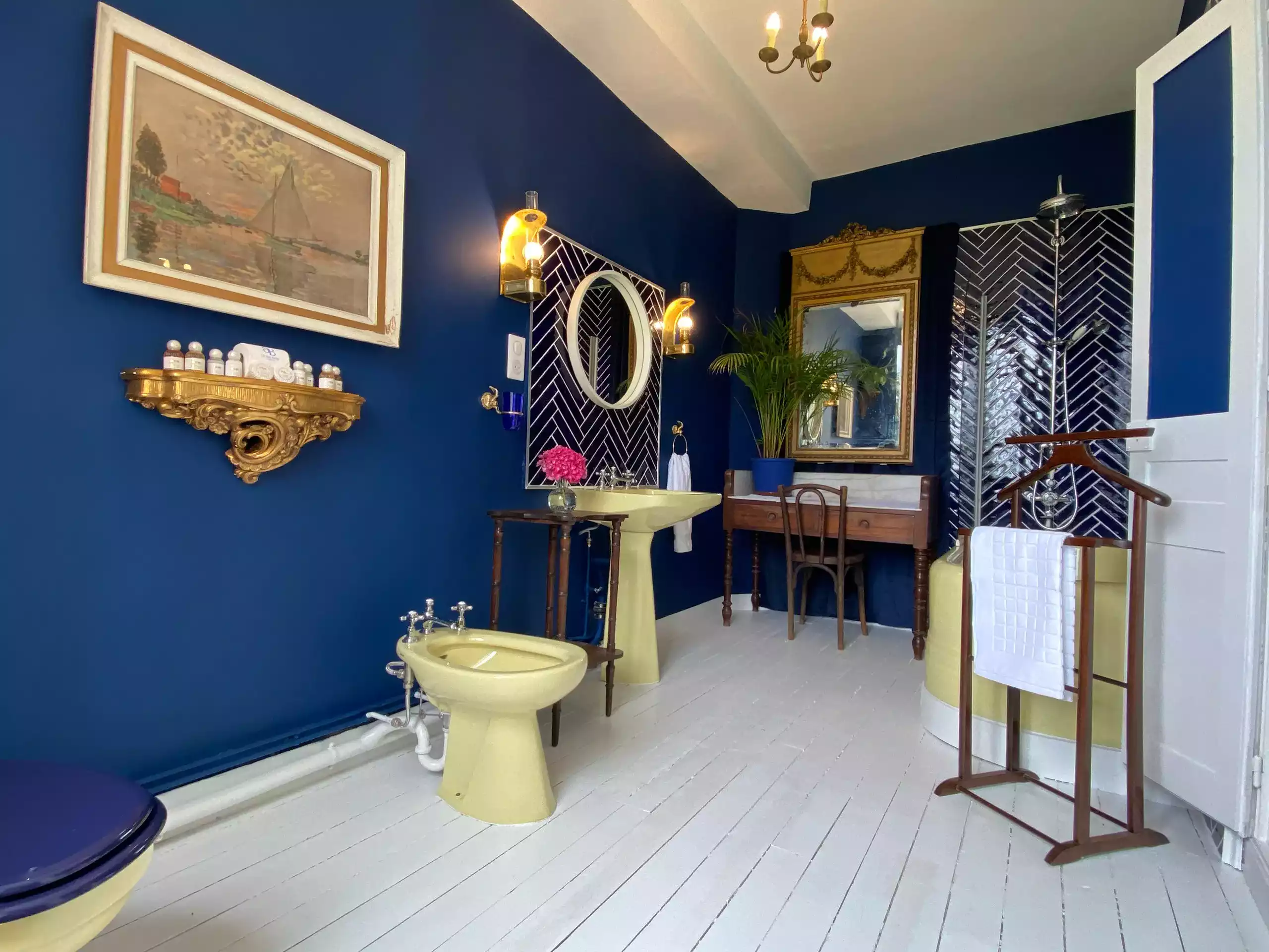 Salle de bain Marina équipée d'un baignoire avec colonne de douche, une coiffeuse, trois miroirs, un bidet et des toilettes - Suite Marina Château Le Bas Bleu