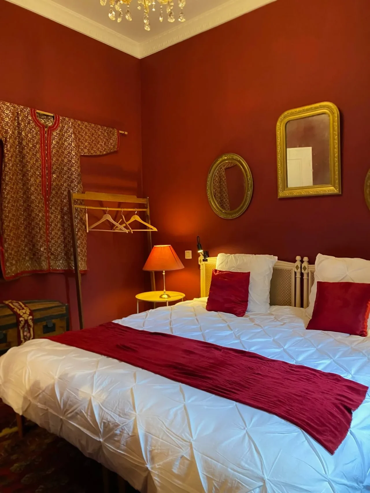 Chambre rouge avec lit blanc et coussins rouges