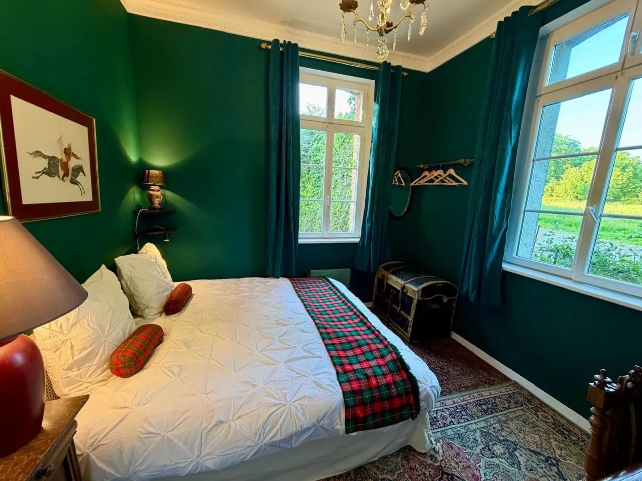 Chambre verte élégante avec lit et grandes fenêtres