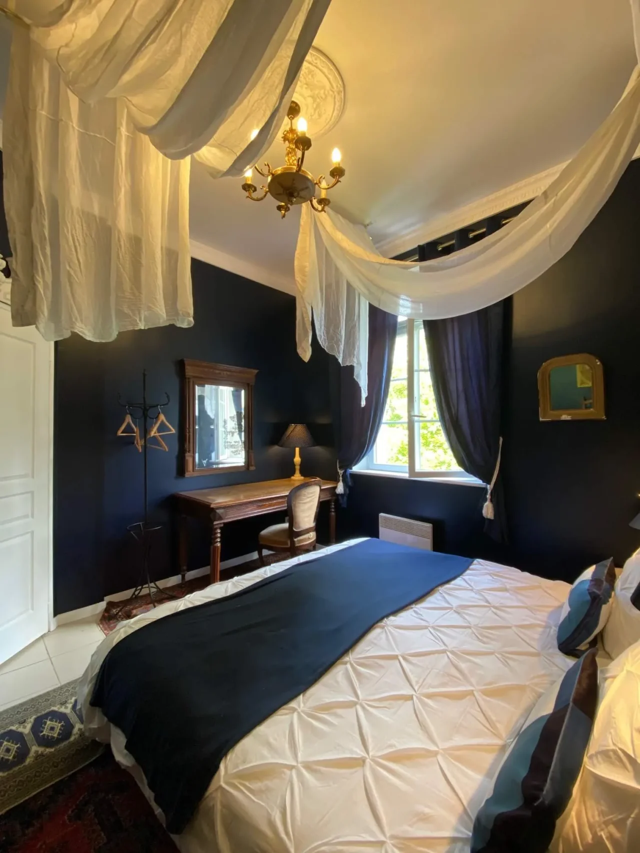 Chambre élégante aux murs bleus et baldaquin blanc