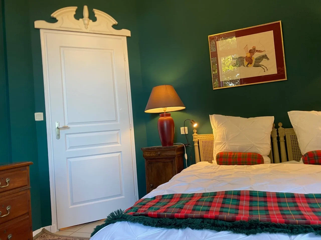 Chambre cosy aux murs verts et lit blanc