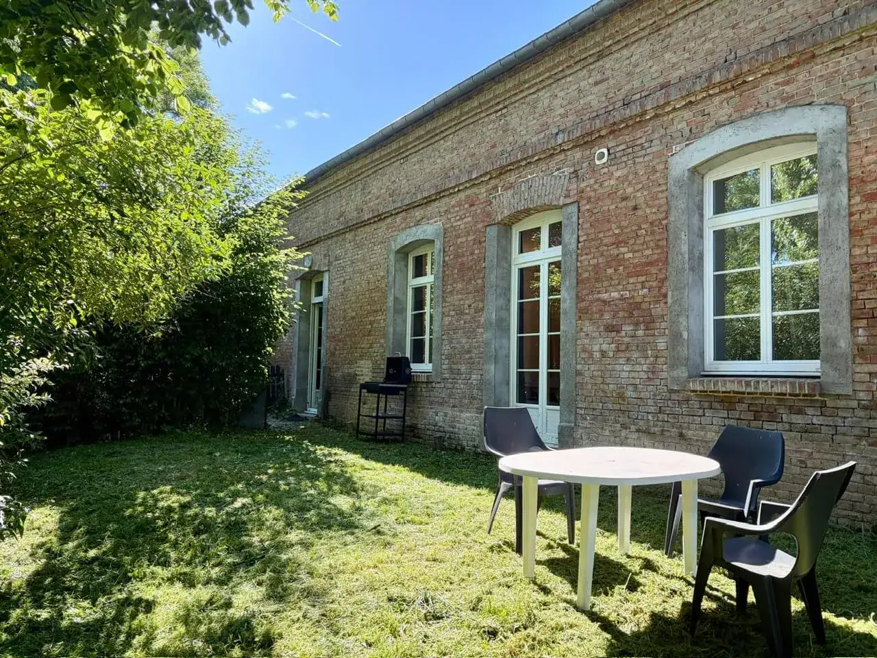 Jardin avec table devant maison en briques