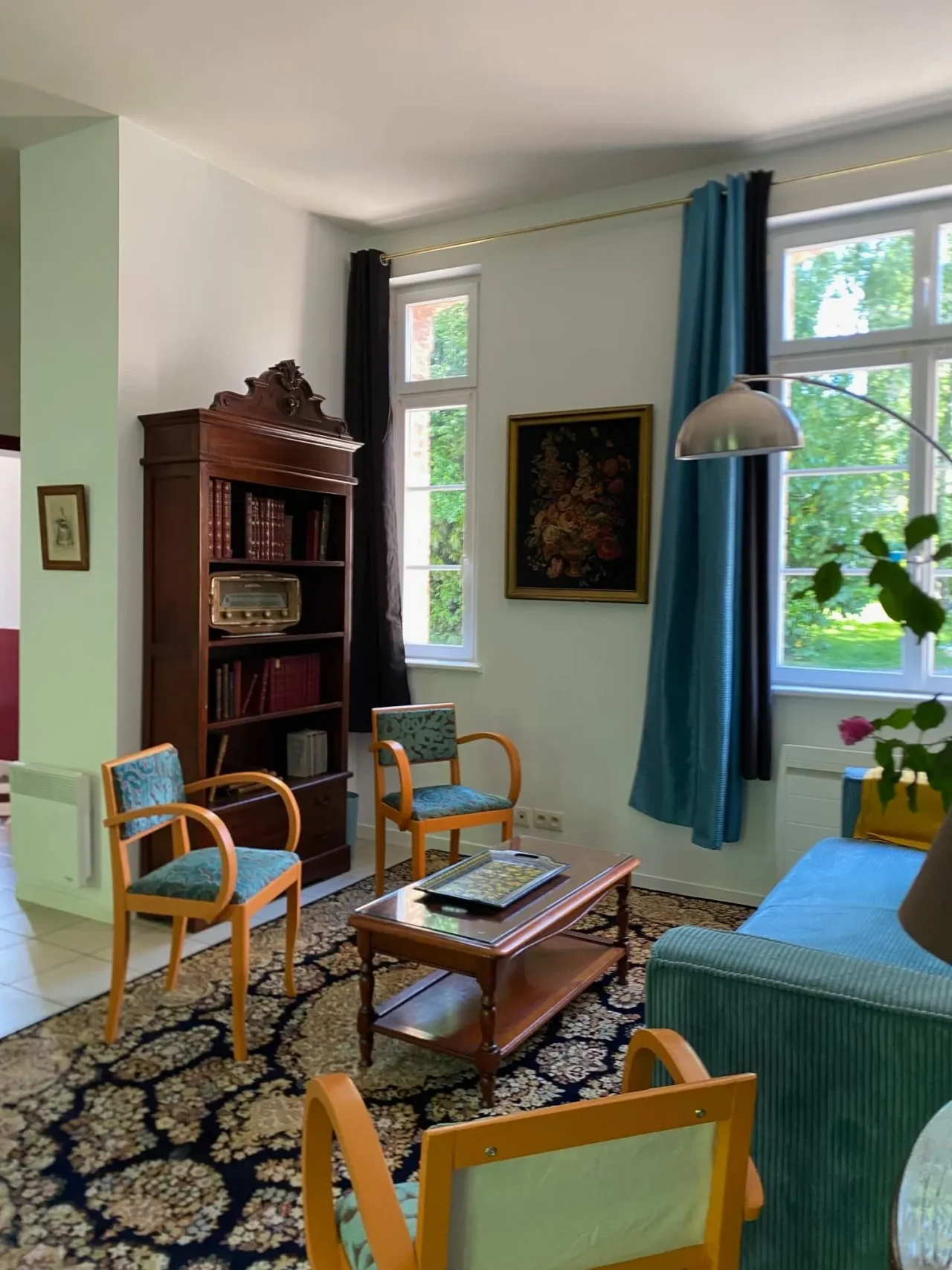 Salon lumineux avec bibliothèque et fauteuils vintage