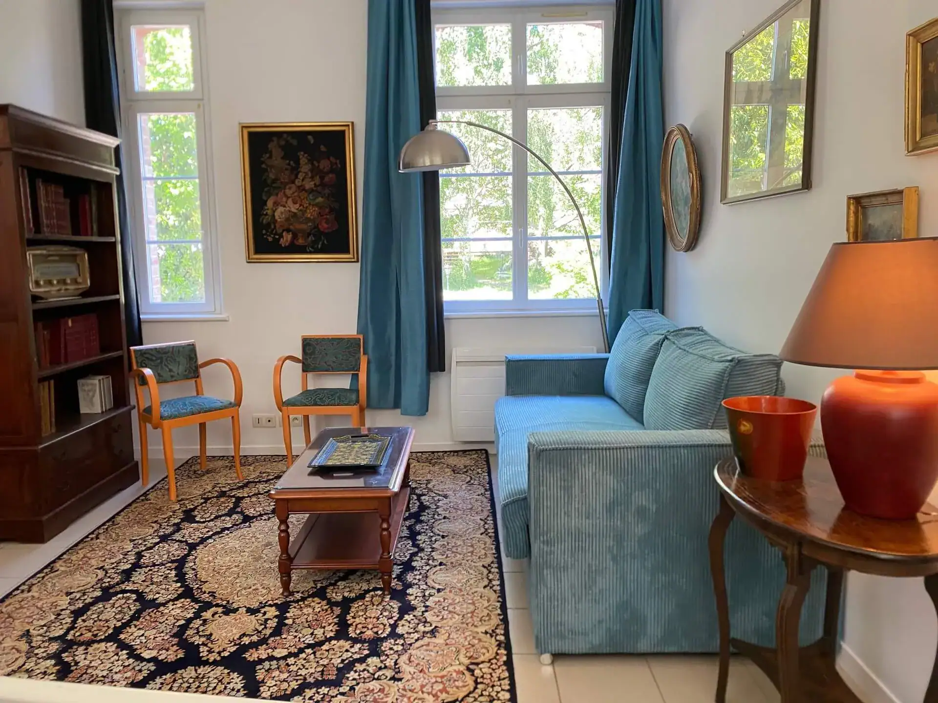 Salon cosy avec canapé bleu et bibliothèque